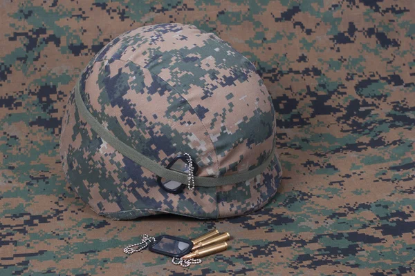 Kevlar helmet with dog tags and cartridges on camouflage cover — Stock Photo, Image