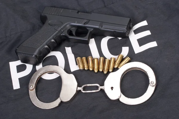 Silah mermisi ve kelepçe ile polis kavramı — Stok fotoğraf