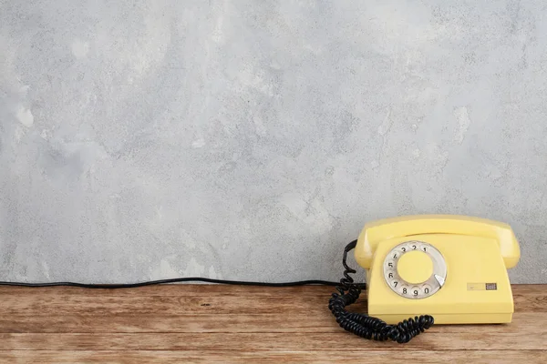 Vintage Amarelo Telefone Discagem Rotativa Mesa Madeira Frente Fundo Concreto — Fotografia de Stock