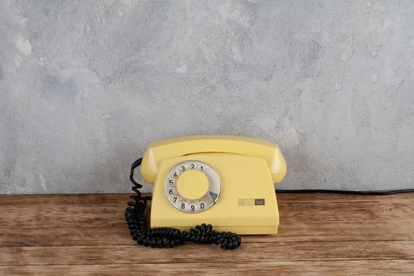 Vintage Κίτρινο Περιστροφικό Καντράν Τηλέφωνο Ξύλινο Τραπέζι Στο Μπροστινό Γκρι — Φωτογραφία Αρχείου
