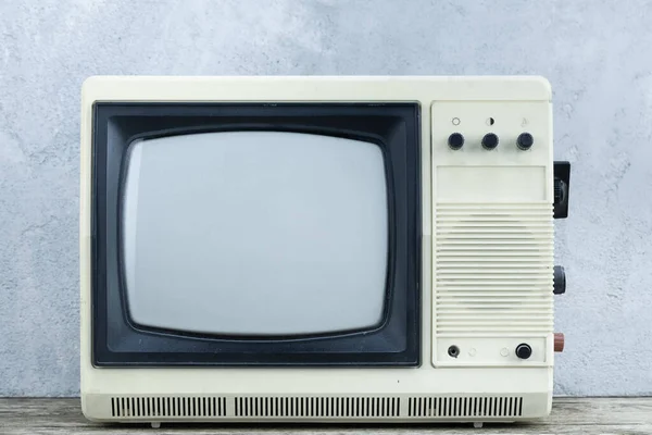 老式复古模拟小型电视机架在木制地板前灰色混凝土墙背景板上 — 图库照片