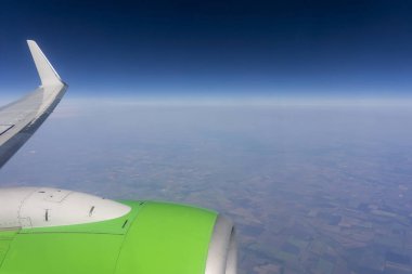 Uçak penceresinden, yeryüzünün ve mavi gökyüzünün uçsuz bucaksız genişliğinde, yaz günü.
