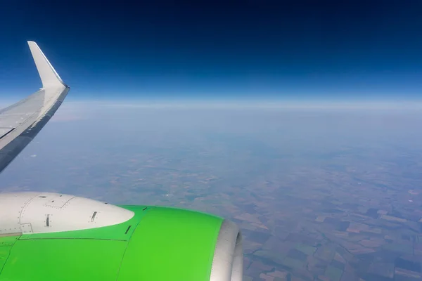 view from the plane window, on the endless expanses of the earth and the blue sky, summer day