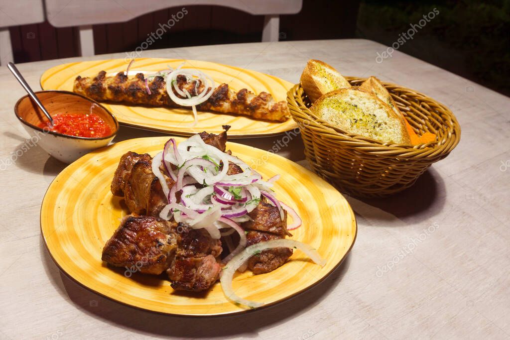 Apetitivo, delicioso kebab y shish kebab con salsa de chile de tomate