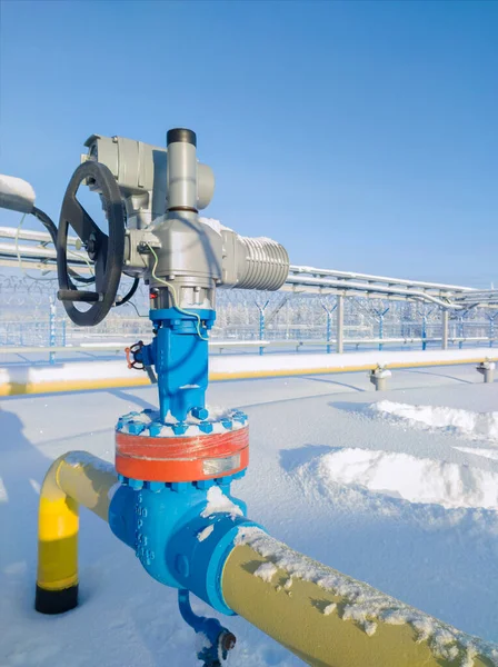 Gate valve with handwheel and electric drive. Covering the section of the condensate pipeline. The concept of oil, gas industry. Industrial site background. Winter industrial landscape. Far north