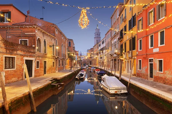 ヴェネツィア クリスマスライトと夕暮れ時の運河の上のイタリアの街並み — ストック写真