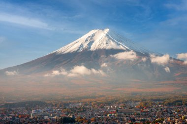 Mt. Fuji towers over Fujiyoshida, Japan in autumn season.