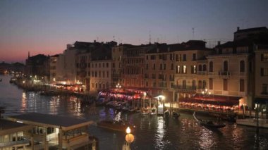 Venice, Italy overlooking boats and gondolas in the Grand Canal at dusk. 