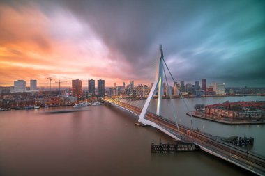 Rotterdam, Netherlands, city skyline over the river at twilight.