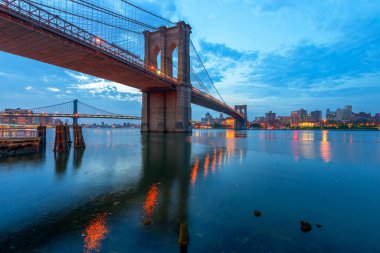 Brooklyn Köprüsü New York 'ta, New York' ta, Alacakaranlıkta Doğu Nehri 'ni geçiyor.