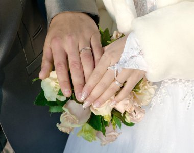 damat ve nişanlısı bir arka planda bir buket gül dan el