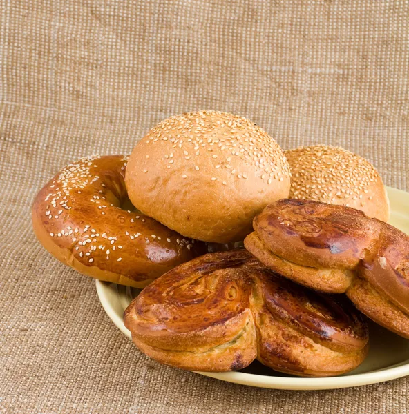 Rolls with a cinnamon and sesame lie on a dish — Stock Photo, Image