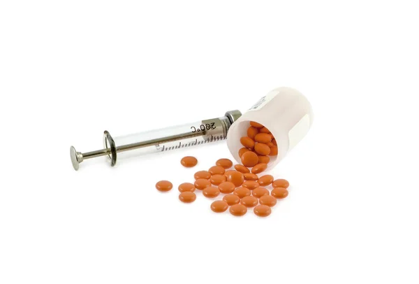 Siringa e pillole su sfondo bianco — Foto Stock