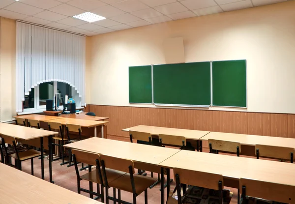 Sala de clase con una junta escolar y escritorios escolares — Foto de Stock