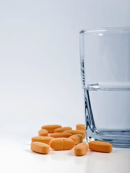 Glass of water and vitamins — Stock Photo, Image