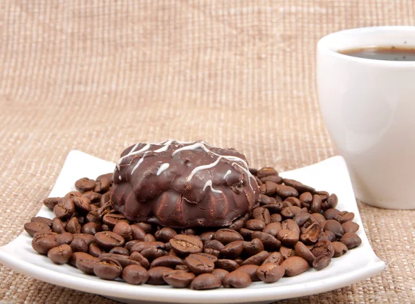 Шоколадная выпечка лежит на кофейном шине на заднем плане чашки — стоковое фото