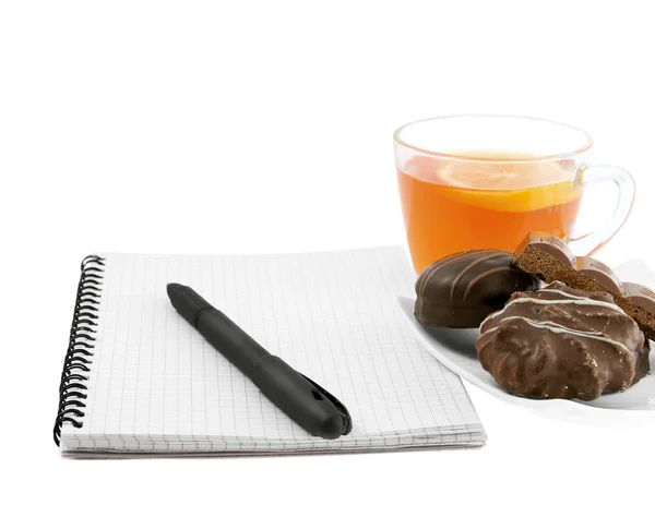 Cuaderno y pluma sobre un té de fondo y galletas — Foto de Stock
