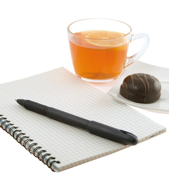 Ноутбук с ручкой и чаем с лимоном на белом фоне — стоковое фото
