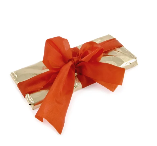 Gold wrapping is bandaged by a red ribbon — Stock Photo, Image