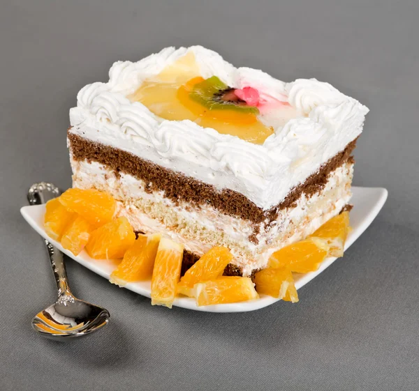 Cake lies on a saucer and tea spoon — Stock Photo, Image