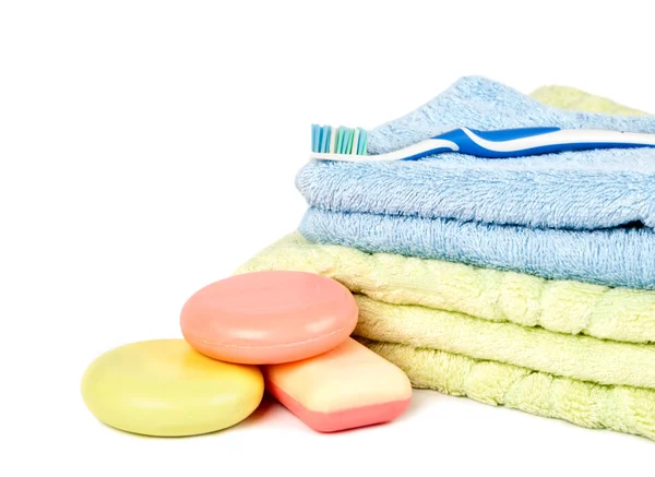 Jabón se encuentra un montón en un fondo de toallas por una pila y cepillo de dientes — Foto de Stock