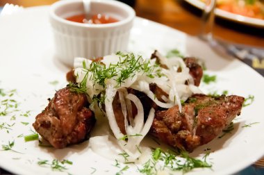 Beyaz bir plaka üzerinde bir yay ile ızgara kavrulmuş et