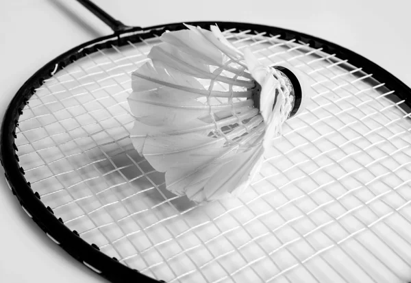 Shuttlecock se encuentra en la raqueta de bádminton de monocromo —  Fotos de Stock