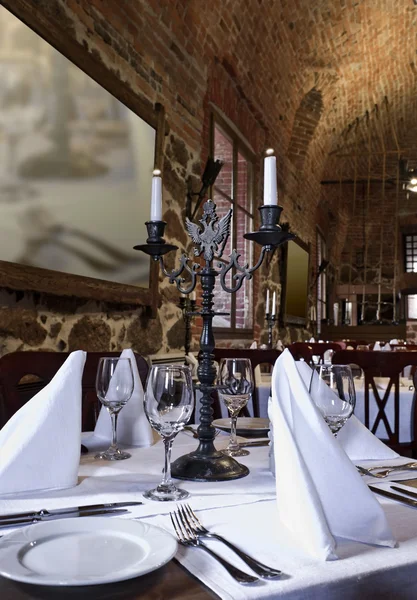 Served table with an ancient candlestick — Stock Photo, Image