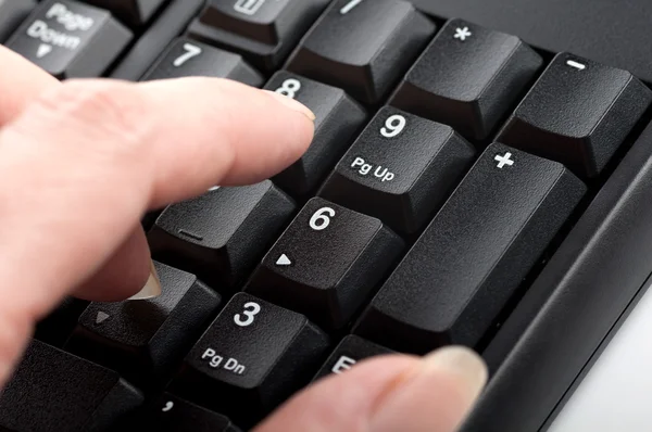Finger women clicks the numbers on the keyboard macro — Stock Photo, Image