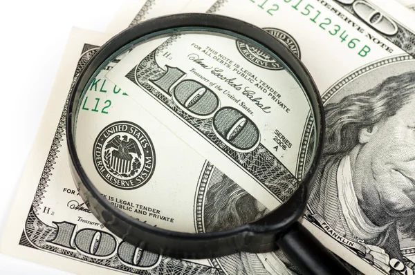 Magnifying glass is on a hundred dollar bill — Stock Photo, Image