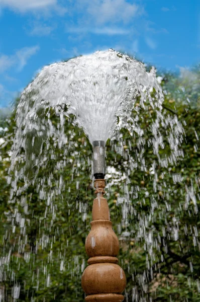 The water flowing from the old fountain on the background of blue sky — Stock Photo, Image