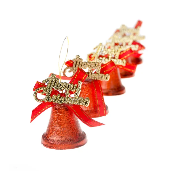 Os sinos vermelhos do Natal estão de pé em uma fileira no branco — Fotografia de Stock