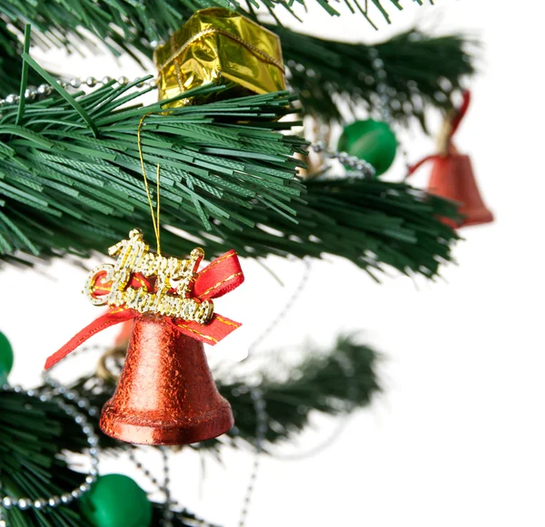 Рождественский колокол и новогодние бусы на ветке елки — стоковое фото