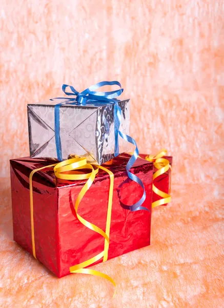 Three gift boxes on an orange background — Stock Photo, Image