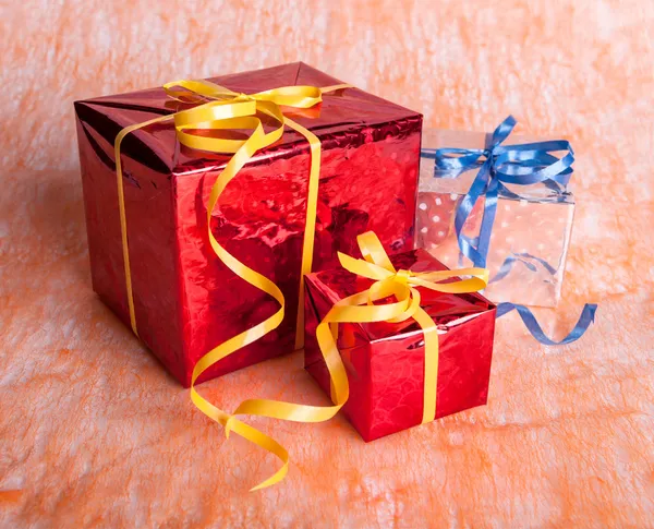 Three gift boxes on an orange background — Stock Photo, Image