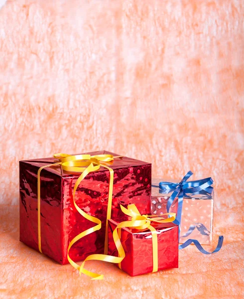 Drie geschenk dozen op een oranje achtergrond — Stockfoto