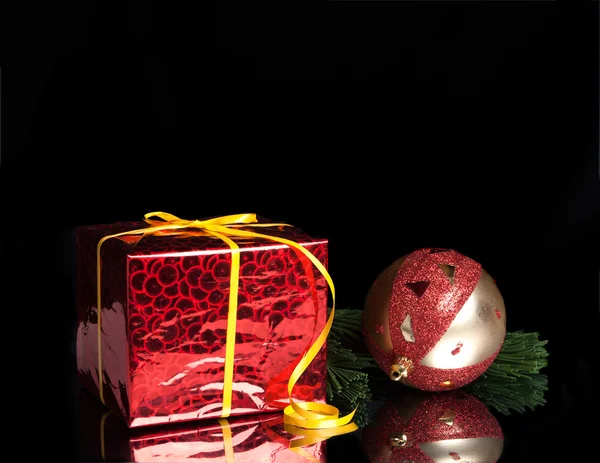 Gift,Christmas ball on the branch of a tree on a black background — Stock Photo, Image