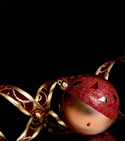 Esfera de árvore de pele com fita ornamental em um fundo preto com reflexão — Fotografia de Stock