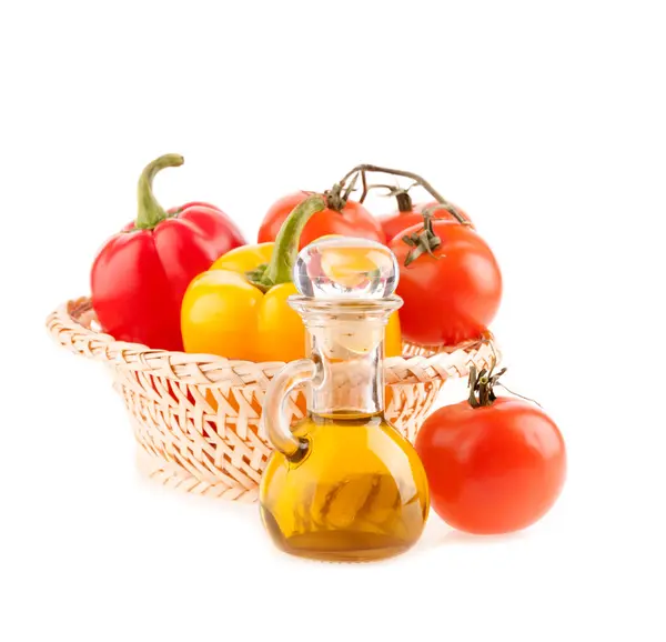 Botol dengan minyak zaitun di latar belakang hidangan berair dengan tomat dan lada — Stok Foto