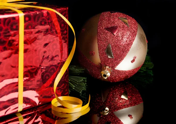 Giocattolo di Natale, regalo, un ramo dell'albero su uno sfondo nero Fotografia Stock