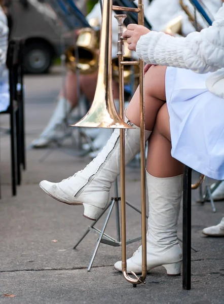 Posaune steht Mädchen in weißen Stiefeln zu Füßen — Stockfoto