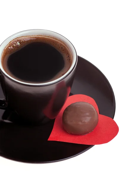 Шоколадные конфеты на бумаге сердце и чашку черного кофе — стоковое фото