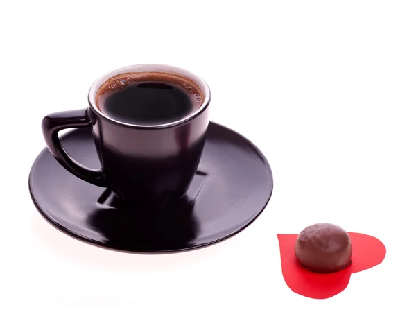 Dulces de chocolate en el corazón de papel y taza de café negro — Foto de Stock
