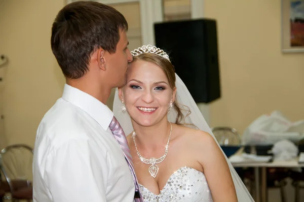 Bruidegom wordt gedrukt zijn lippen op haar voorhoofd van de bruid — Stockfoto