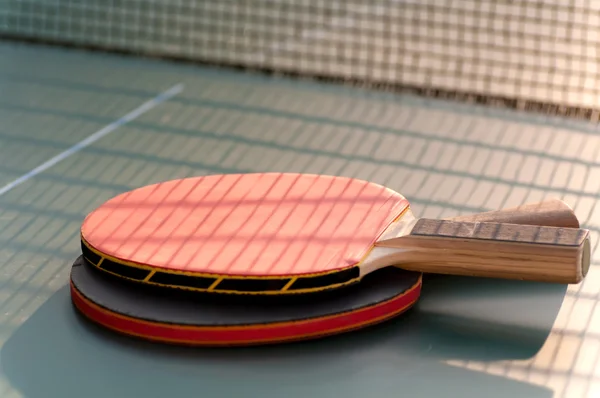 Twee tennisracket op de tafel in de buurt van het raster — Stockfoto