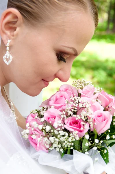 Bruid verlaagd haar ogen in een boeket van bloemen — Stockfoto