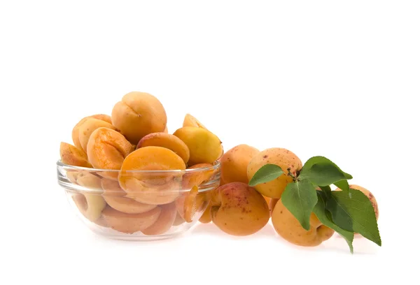 Вырезать абрикосы с листьями в тарелке — стоковое фото