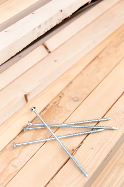 Four nails lie on the boards — Stock Photo, Image