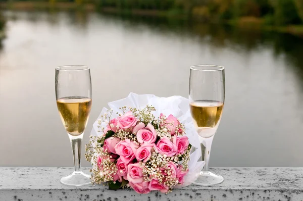 Two glasses of champagne and a bouquet of flowers — Stock Photo, Image