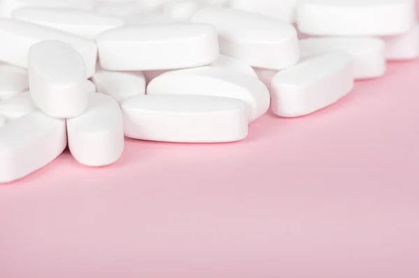 Белая таблетка крупным планом розовый — стоковое фото